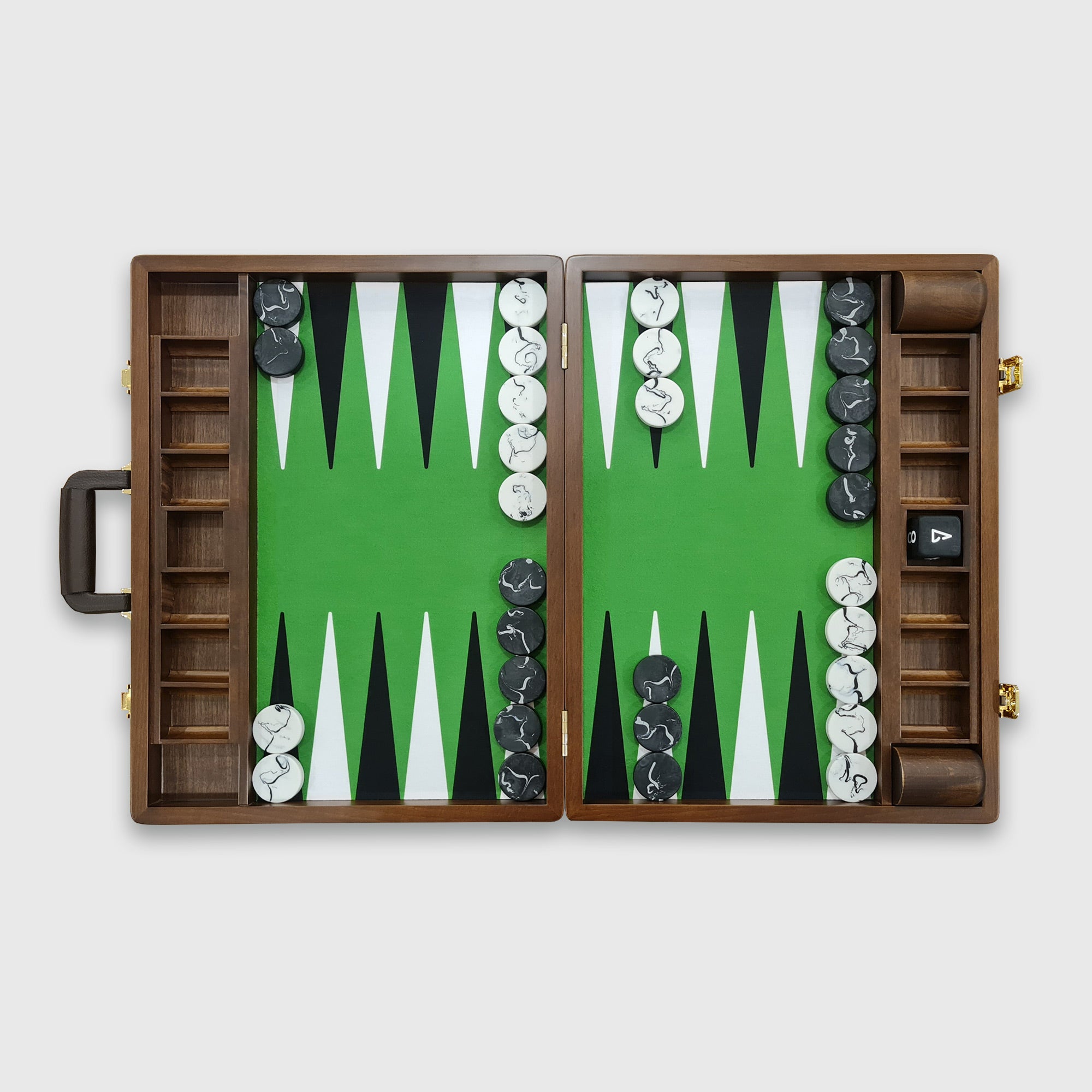 A tournament-sized Monte Carlo backgammon board with green and brown playing surfaces, accompanied by a set of black and white checkers, a doubling cube, and dice cups, with the board's case partially visible.