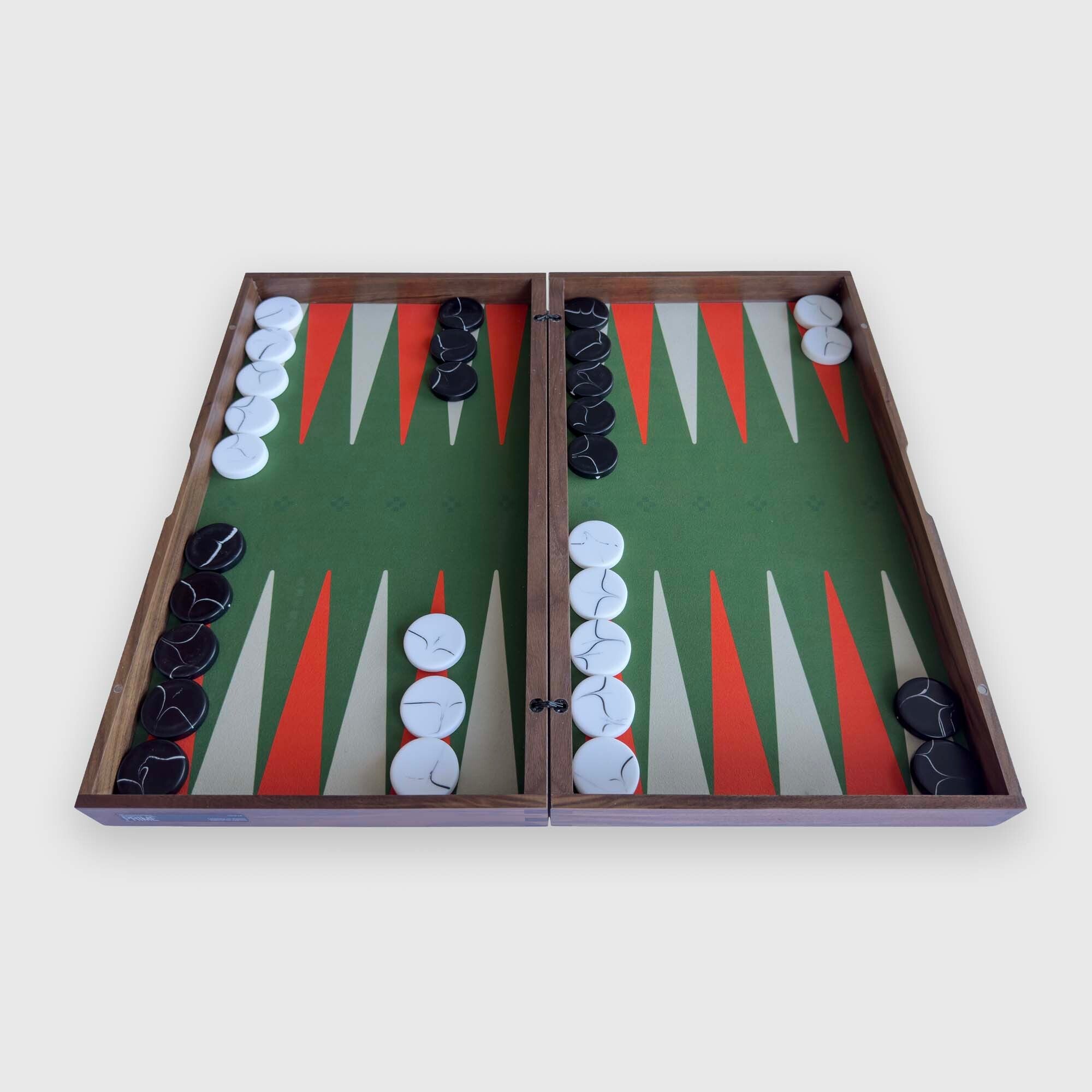 An open "PRIME" wooden backgammon board with a green playing field, orange and white triangular points, and black and white checkers, photographed from above on a light gray background.