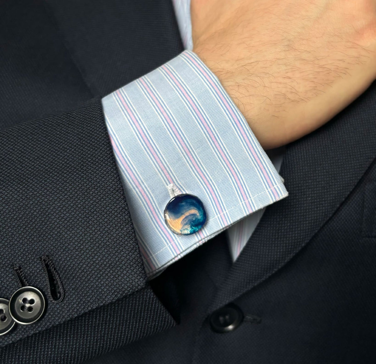 Checker cufflinks worn on a shirt cuff