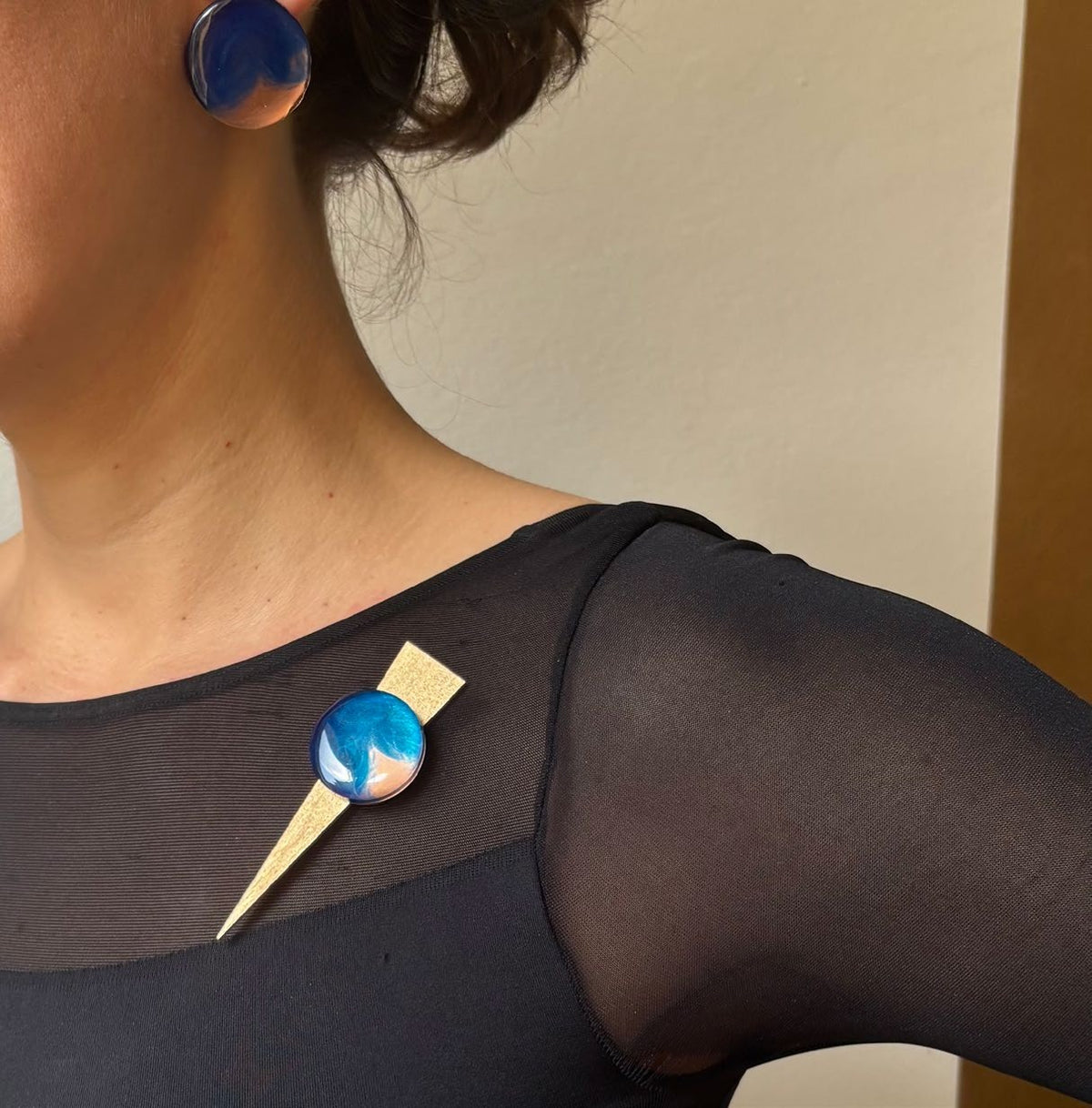 Checker on Point brooch worn
